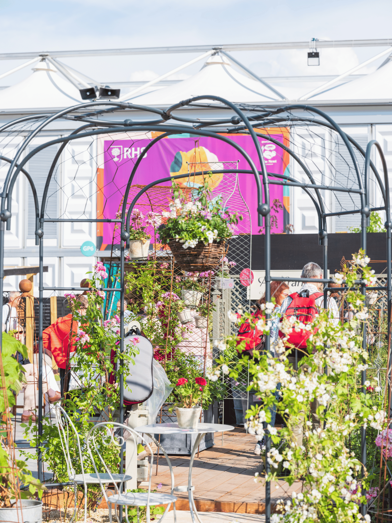 Royal Horticultural Society Garden - Chelsea Flower Show 2025 - a range of Agriframes products, including Obelisks, Round Gazebo, bistro set, hanging basket