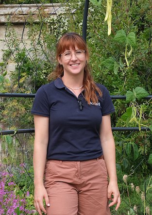 Portrait of Julia Burton from Borde Hill, stood in front of a floral background