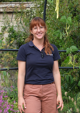 Portrait of Julia Burton from Borde Hill, stood in front of a floral background