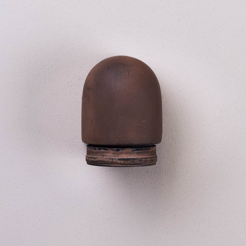 Brown bullet casing on a light gray background