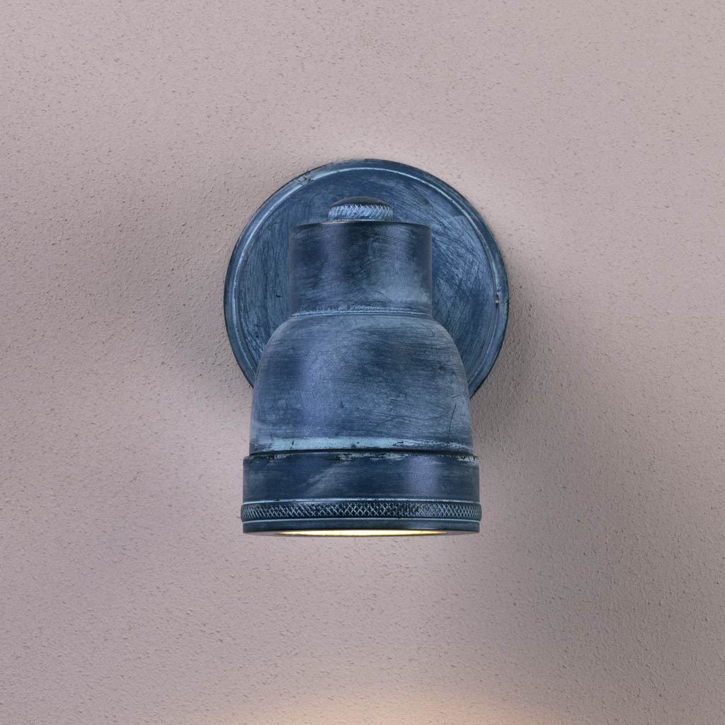 Blue wall-mounted light fixture on a beige wall