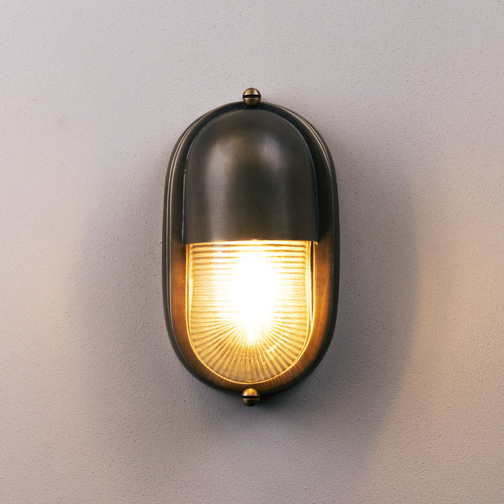 Wall-mounted outdoor light fixture on a gray wall