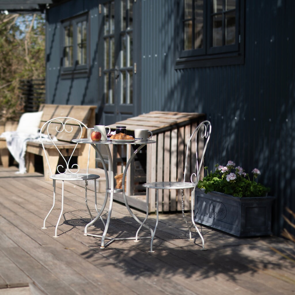 Provence Vintage Bistro Set in stone white with a dark grey background and a zinc planter behind it 
