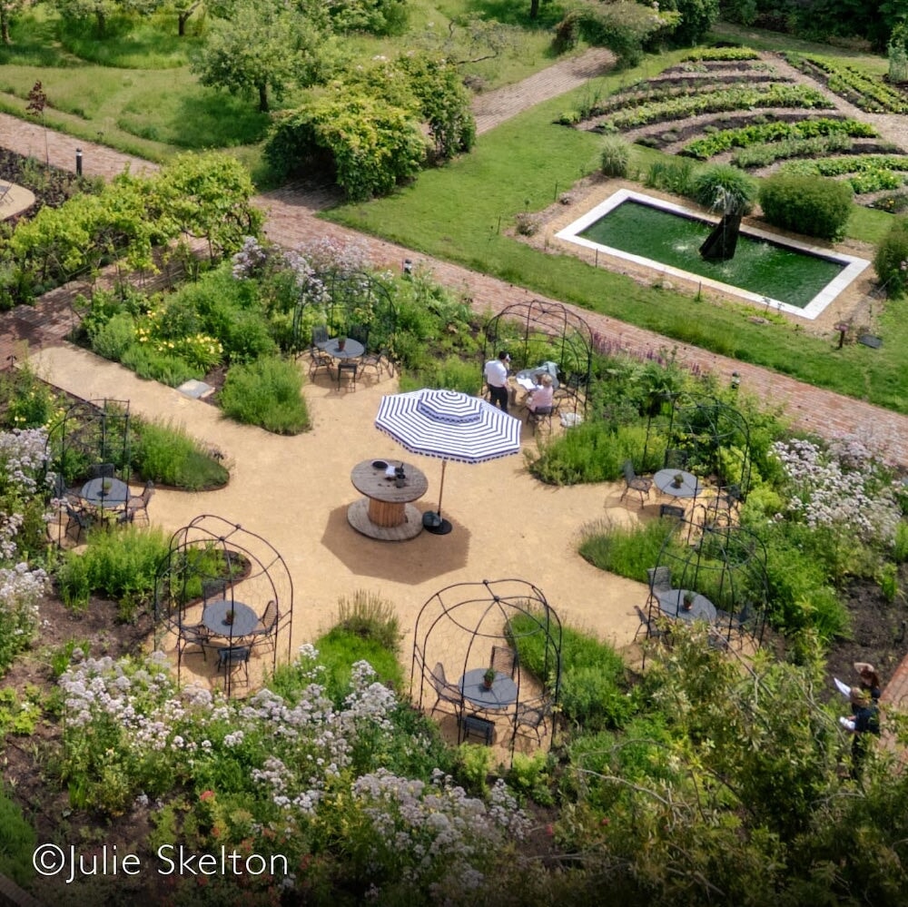 Birds eye view of several round arbours in a circle on a round patio with tables and chairs underneath each one
