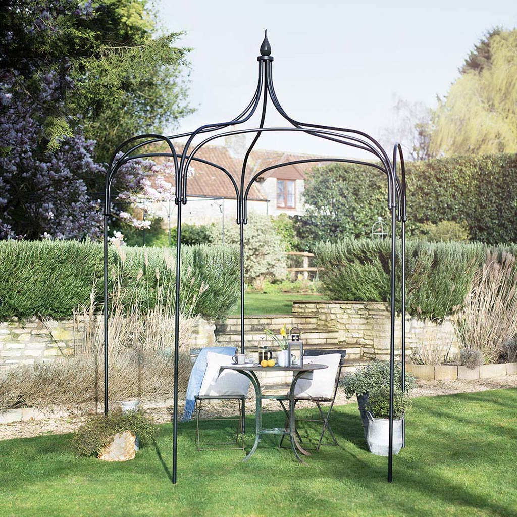 Garden gazebo with outdoor furniture in a backyard setting