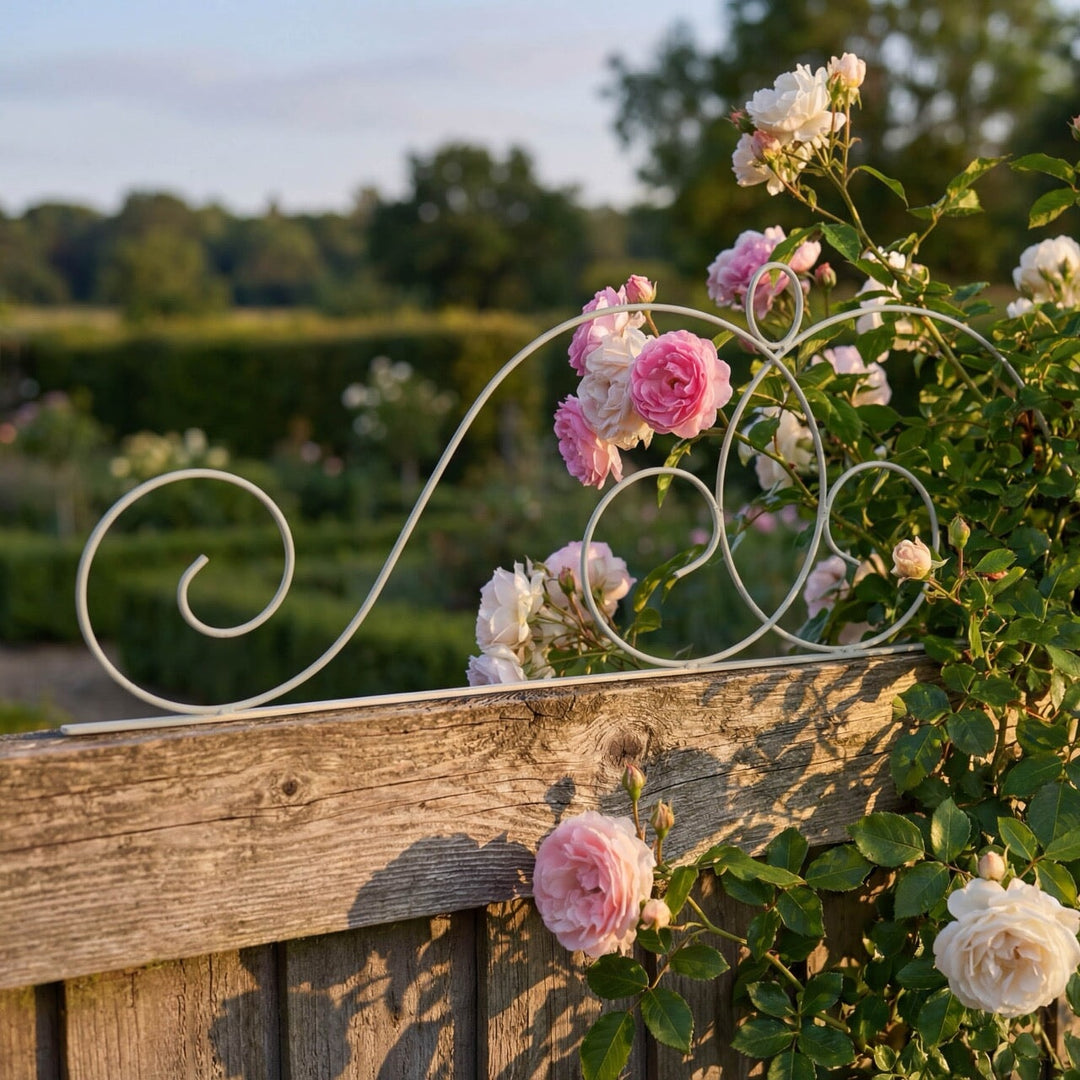 Decorative metal Agriframes Elegance Fence Top Trellis with pink and white flowers against a garden backdrop