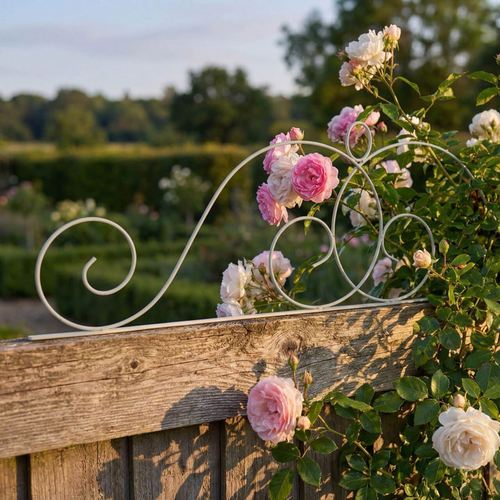 Decorative metal Agriframes Elegance Fence Top Trellis with pink and white flowers against a garden backdrop