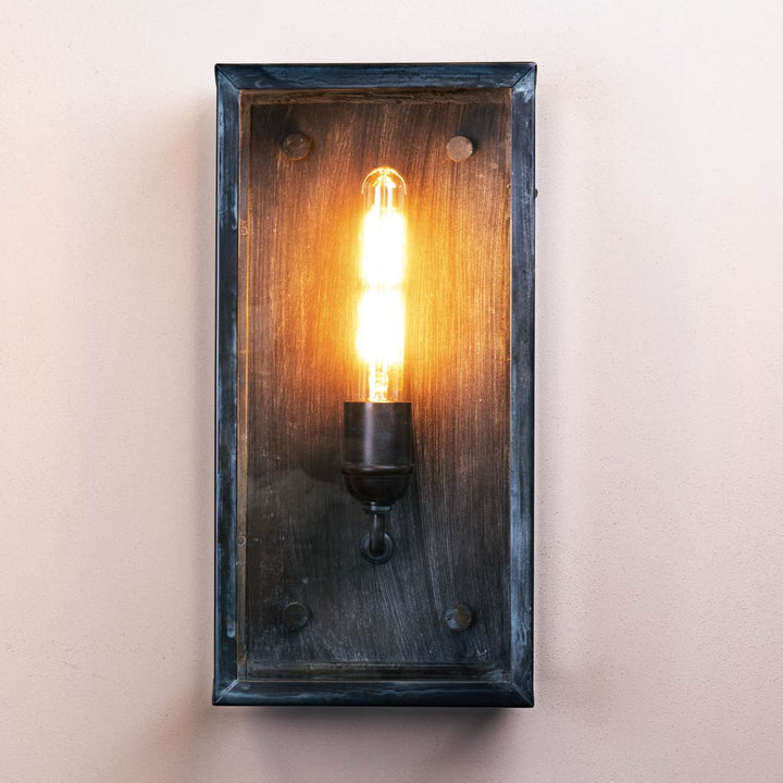Wooden wall sconce with a lit bulb on a plain background