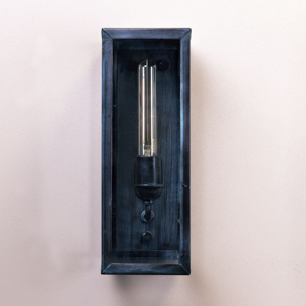 Black wall-mounted light fixture on a beige background