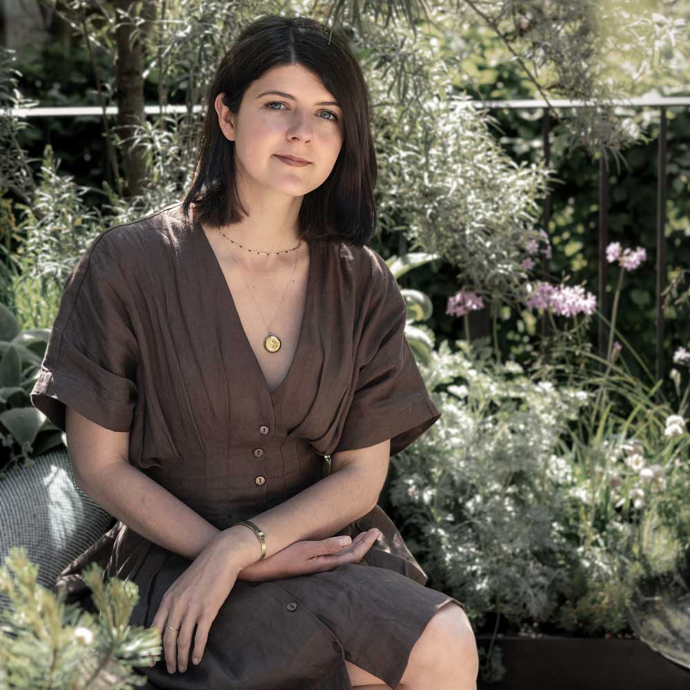 Woman sitting outdoors in a garden setting