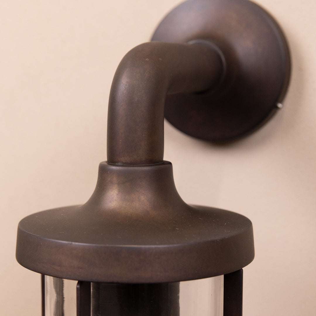 Closeup image of the Agriframes Exmouth Outdoor Wall Lamp in a Bronze finish with its bulb switched off, mounted on a neutral background. 