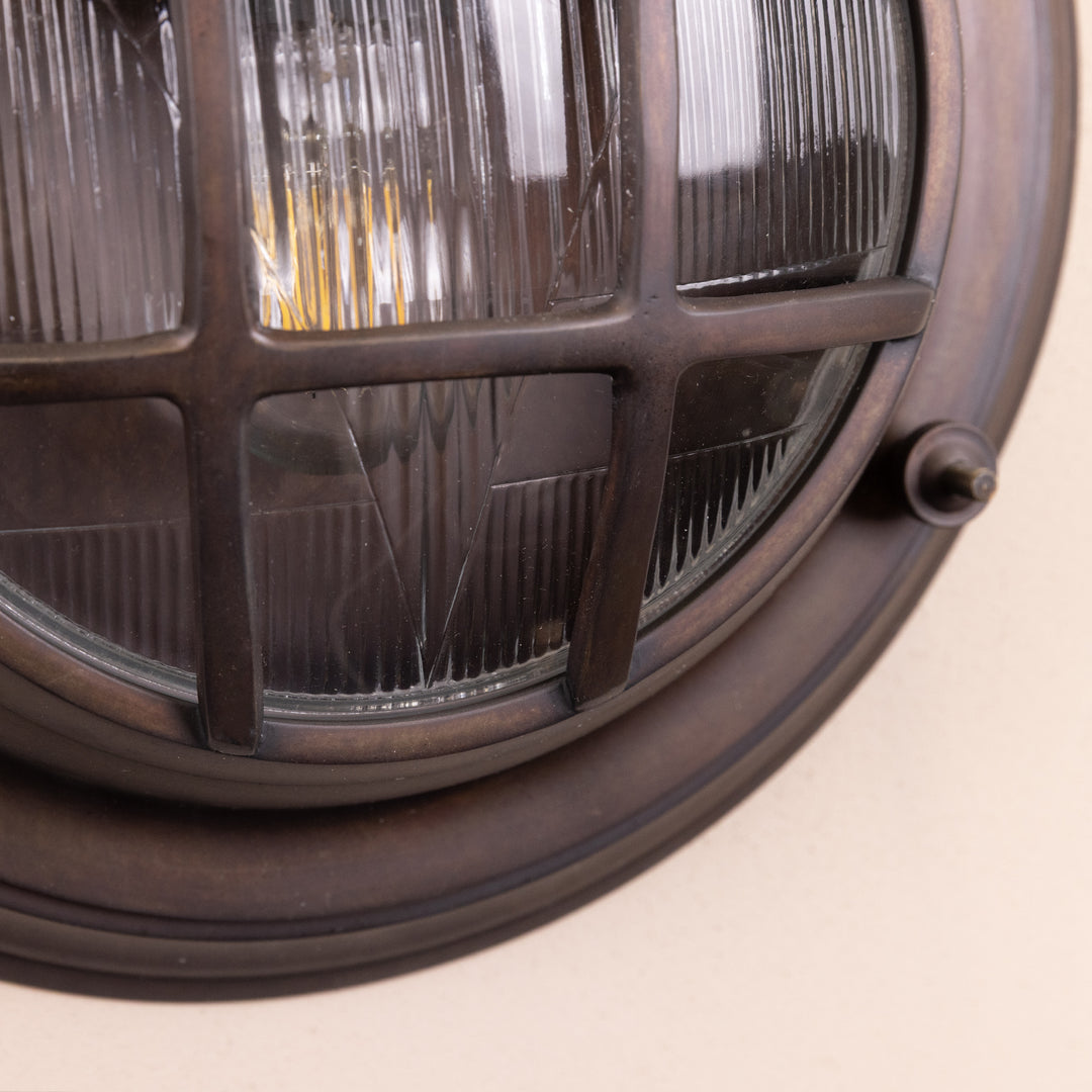 Closeup image of the Agriframes Looe Bulk Head Round Lantern in a Bronze finish. 