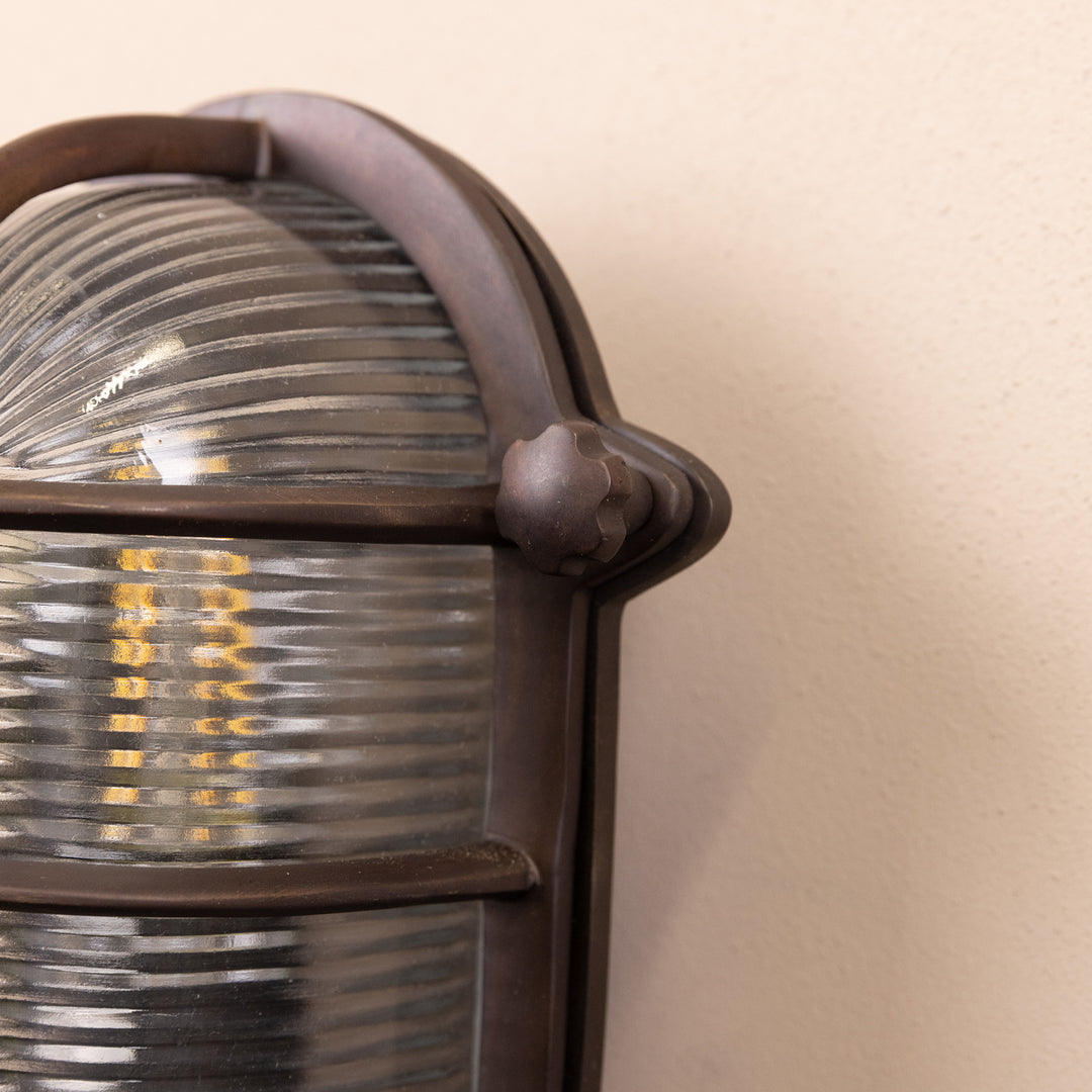 Closeup image of the Agriframes Salcombe Bulk Head Oval Lantern in a Bronze finish. 