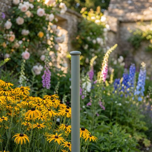 Top half of an Elegance Screen Mounting Pole in a flowerbed