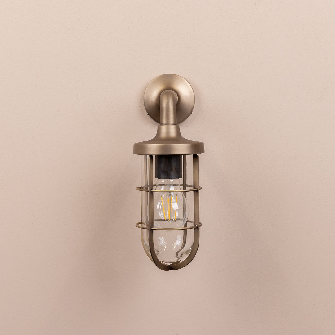 Front on image of the Agriframes Exmouth Outdoor Wall Lamp in a Brass finish with its bulb switched off, mounted on a neutral background. 