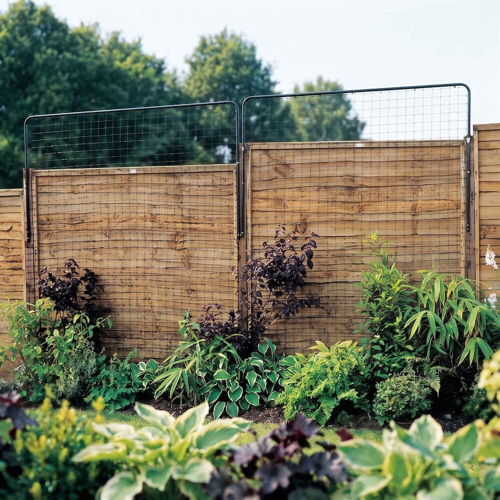Agriframes traditional fence top privacy panels against a wooden garden fence in a flowerbed