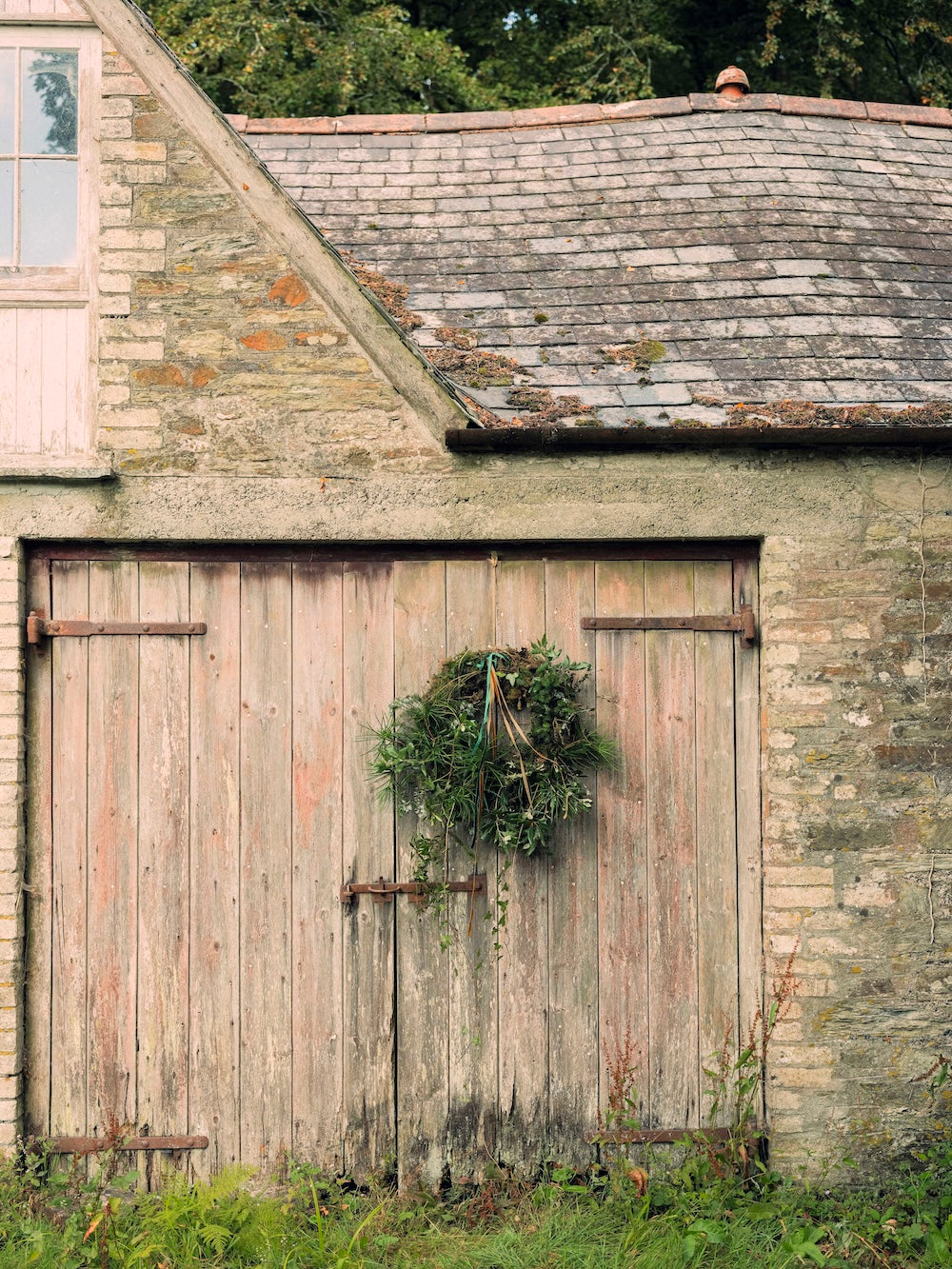 Florist wreath trellis covered in natural materials and hung on a wooden door