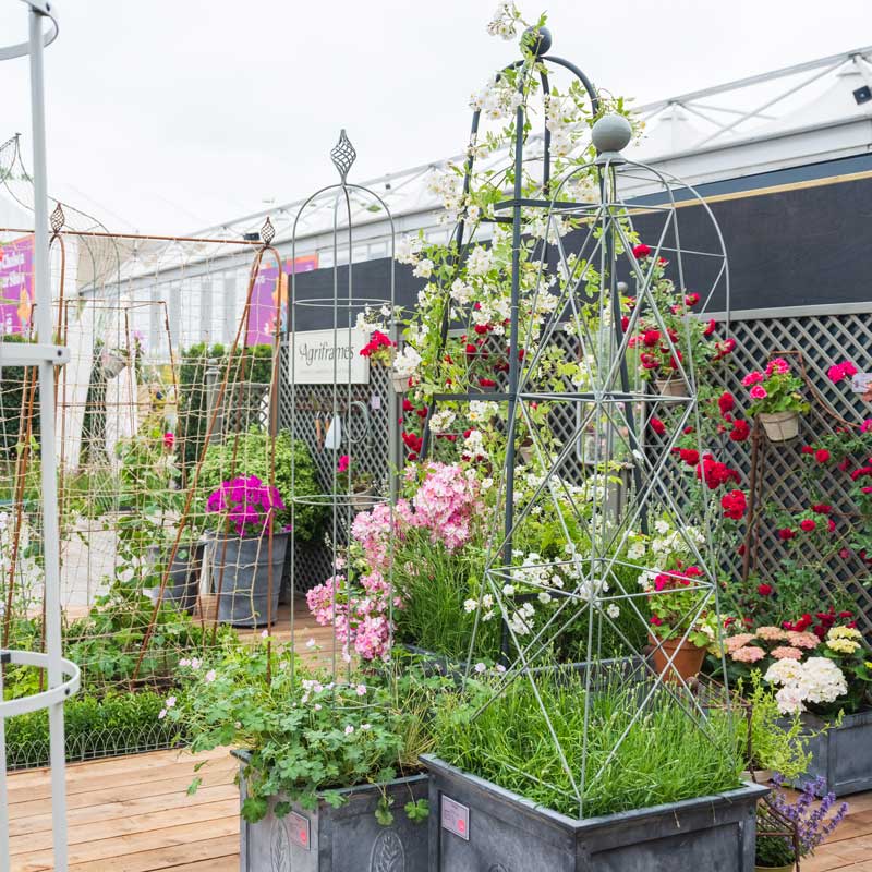 Garden Obelisks at the RHS Chelsea Flower Show with flowers and red roses growing up 