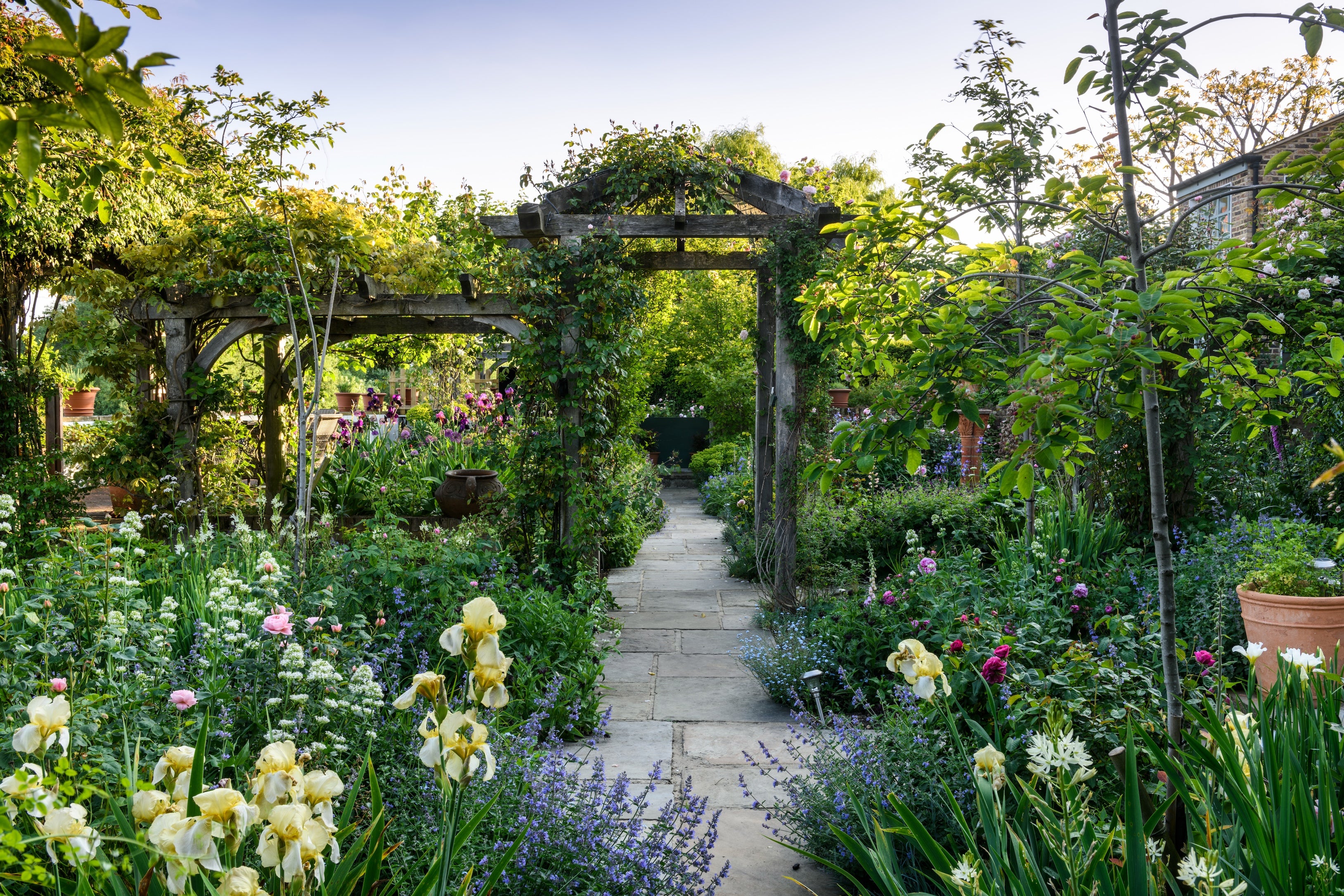 Garden pathway with flowers and a wooden archway
