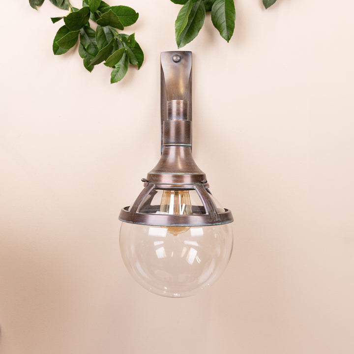 Front on image of the Agriframes Outdoor Wall Lamp in a Copper Patina finish with its bulb turned off, mounted on a neutral background. 