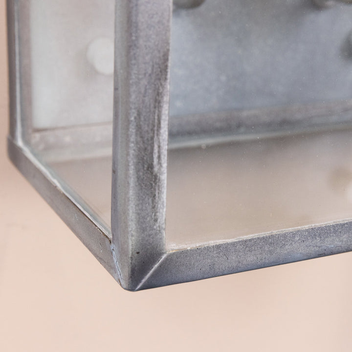 Closeup image of one corner of the Agriframes Marlborough Coach Lantern, highlighting the Old Iron finish and toughened sheet glass. 
