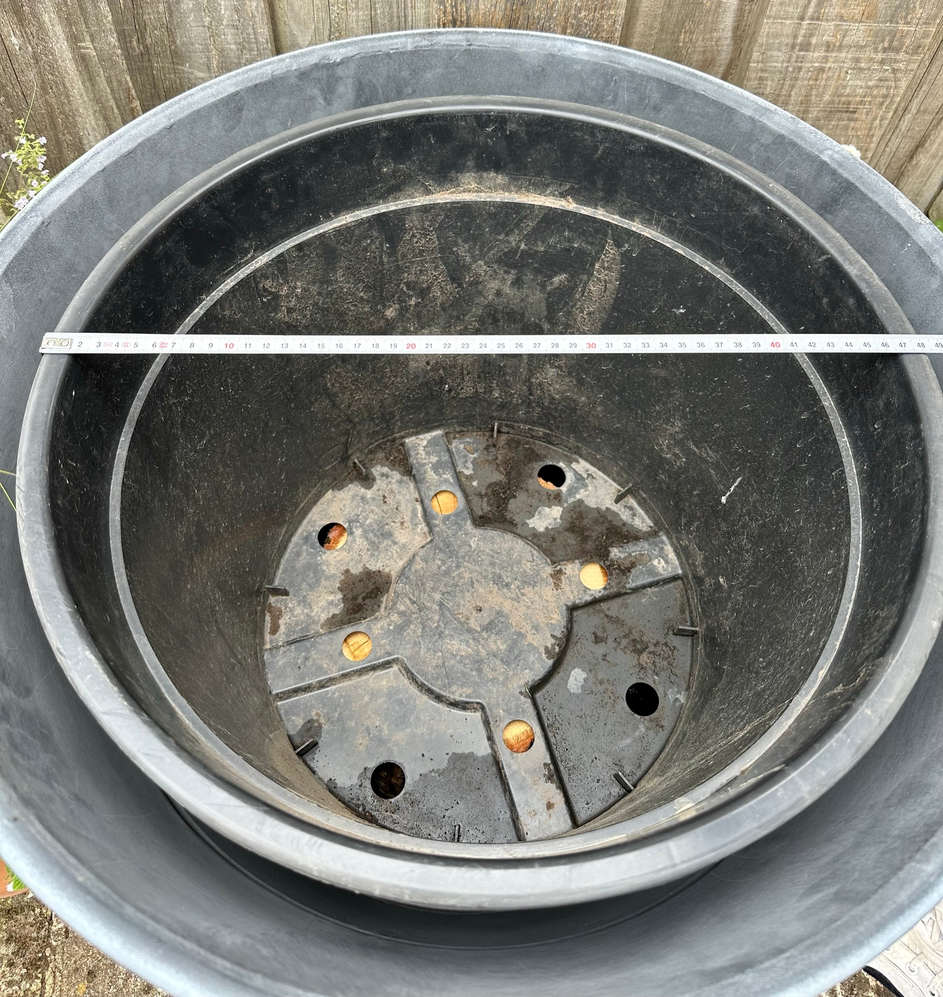 Gray pot with a metal base and measurement tape showing dimensions