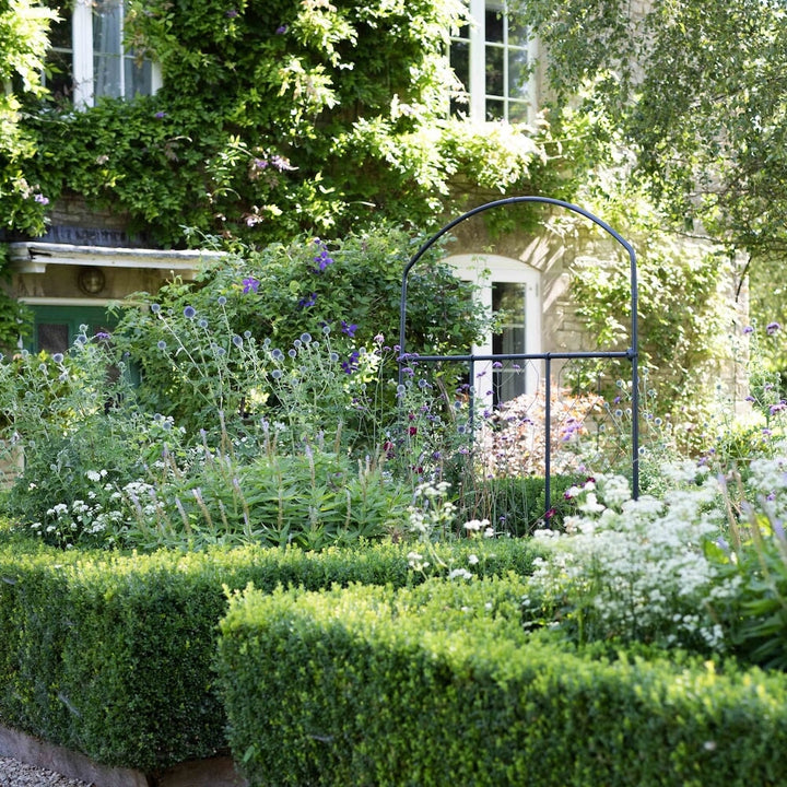 Wide shot of the Agriframes monet fencing screen in a floral garden scene