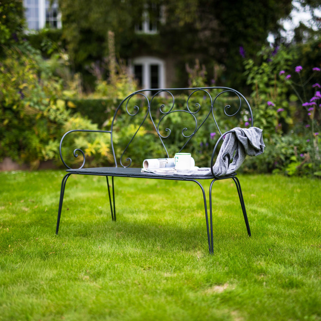 Decorative Agriframes Pavillion Vintage Garden Bench with a cup and saucer on a grassy lawn