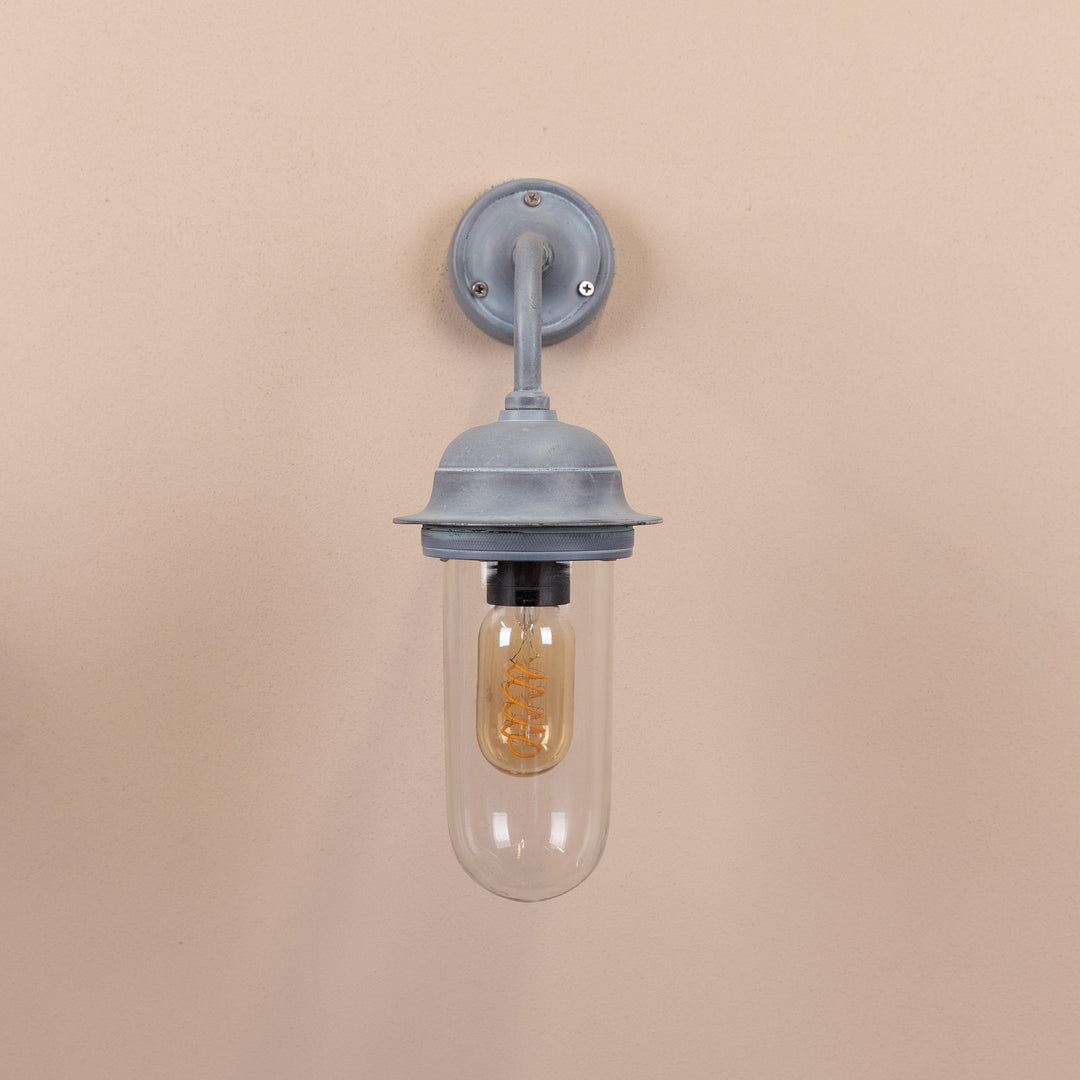 Front on image of the Agriframes Pewsey Outdoor Wall Lamp in an Old Iron finish with its bulb switched off, mounted on a neutral background. 