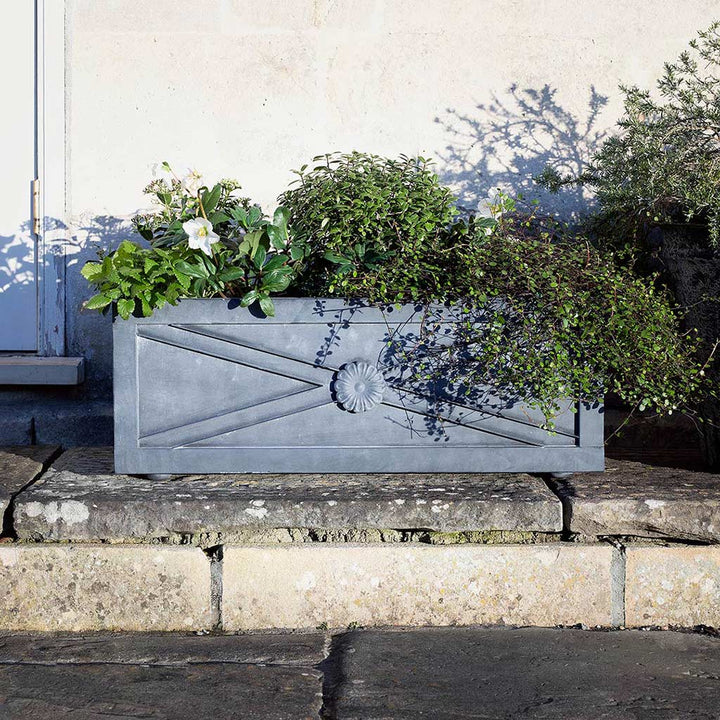 Agriframes Regency Zinc Trough Planter containing several different types of planter on a stone step. 