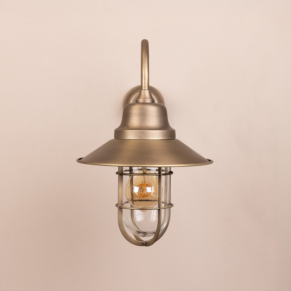 Front on image of the Agriframes Sidmouth Outdoor Wall Lamp in a Brass finish with its bulb switched off, mounted on a neutral background. 