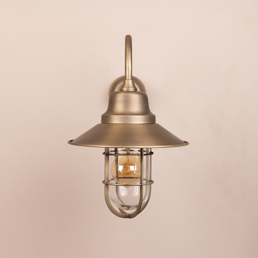 Front on image of the Agriframes Sidmouth Outdoor Wall Lamp in a Brass finish with its bulb switched off, mounted on a neutral background. 