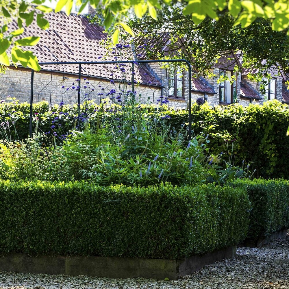 Agriframes standard flat fencing screen in a hedged flowerbed