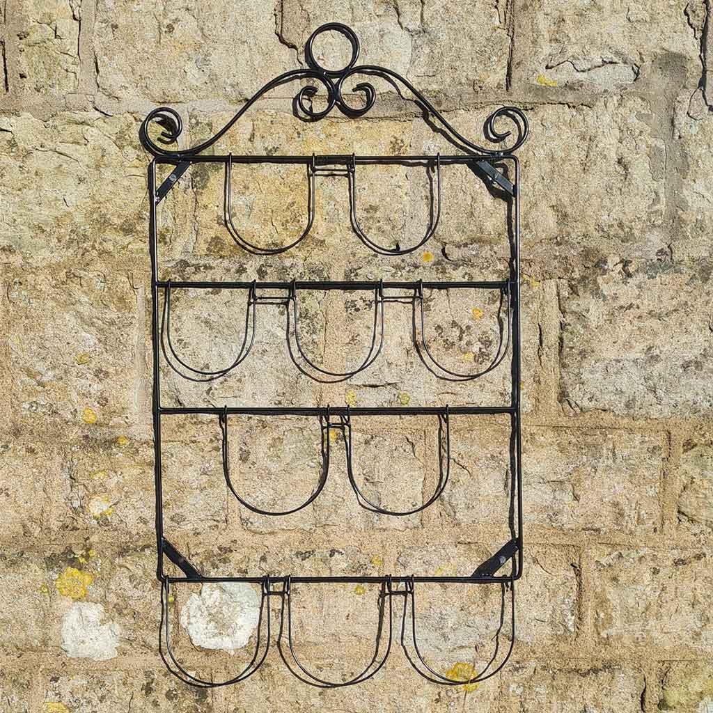 Wrought iron wall-mounted wine rack on a stone wall background